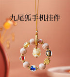 Nine-Tailed Fox crystal pendant flat lay - handcrafted phone charm for prosperity
