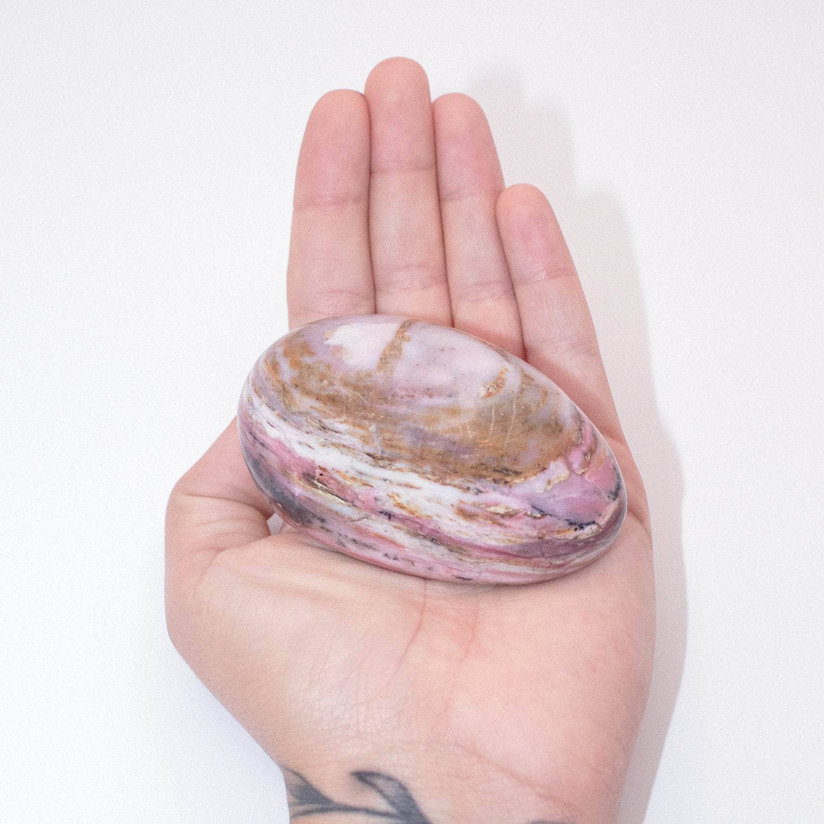 AAA Strawberry Opal palm stone on display with stunning details