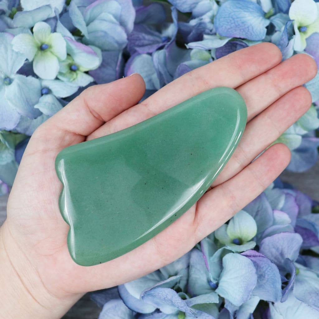 Green Aventurine gua sha tool held in the hand