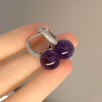 Amethyst S925 silver dangle earrings flat lay on wood slice with flowers, Crystalvana