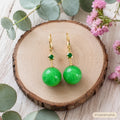 Natural A-grade jadeite yang green round bead earrings model wearing blonde smile ear closeup, Crystalvana