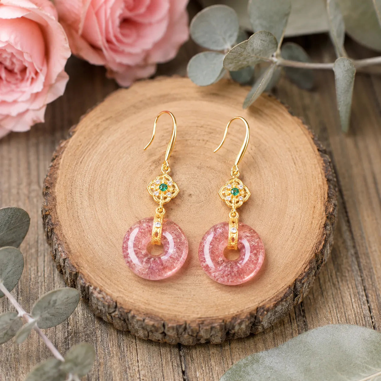 Model wearing natural strawberry quartz gold-tone peace buckle earrings with pink roses and eucalyptus, Crystalvana