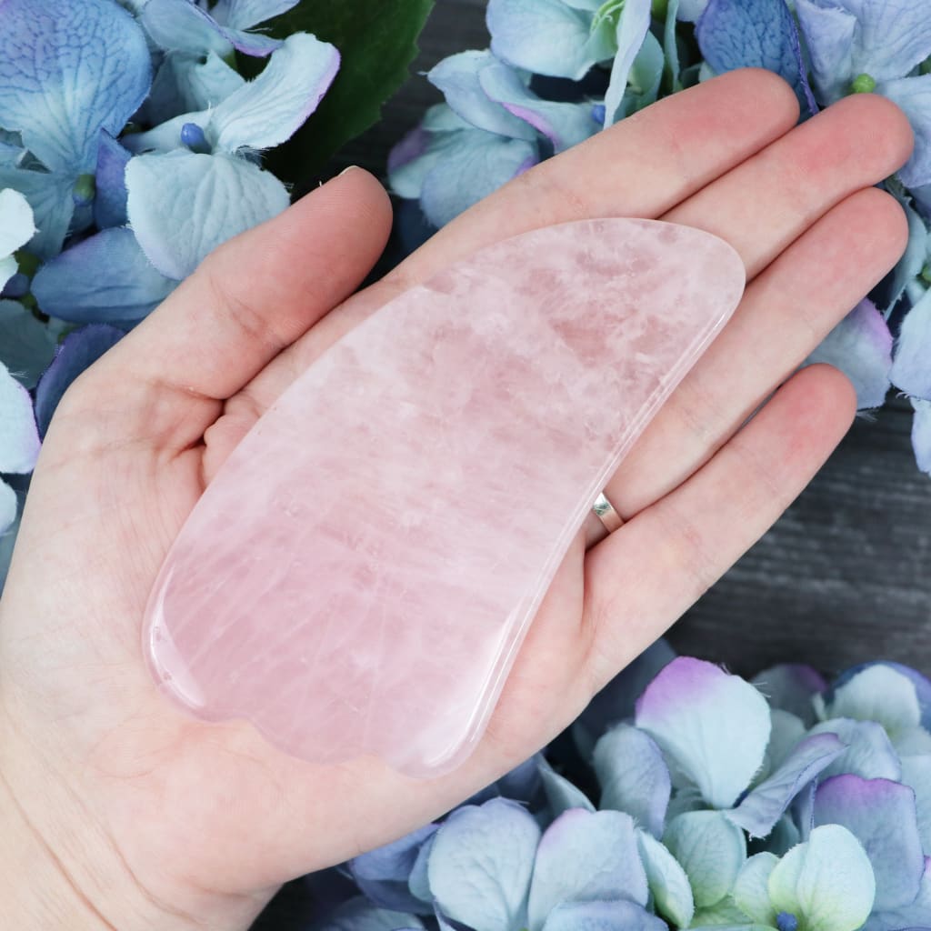 Rose Quartz gua sha tool in its Crystalvana storage pouch