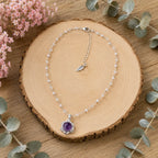 Model smiling wearing amethyst pendant necklace hand on hair, Crystalvana